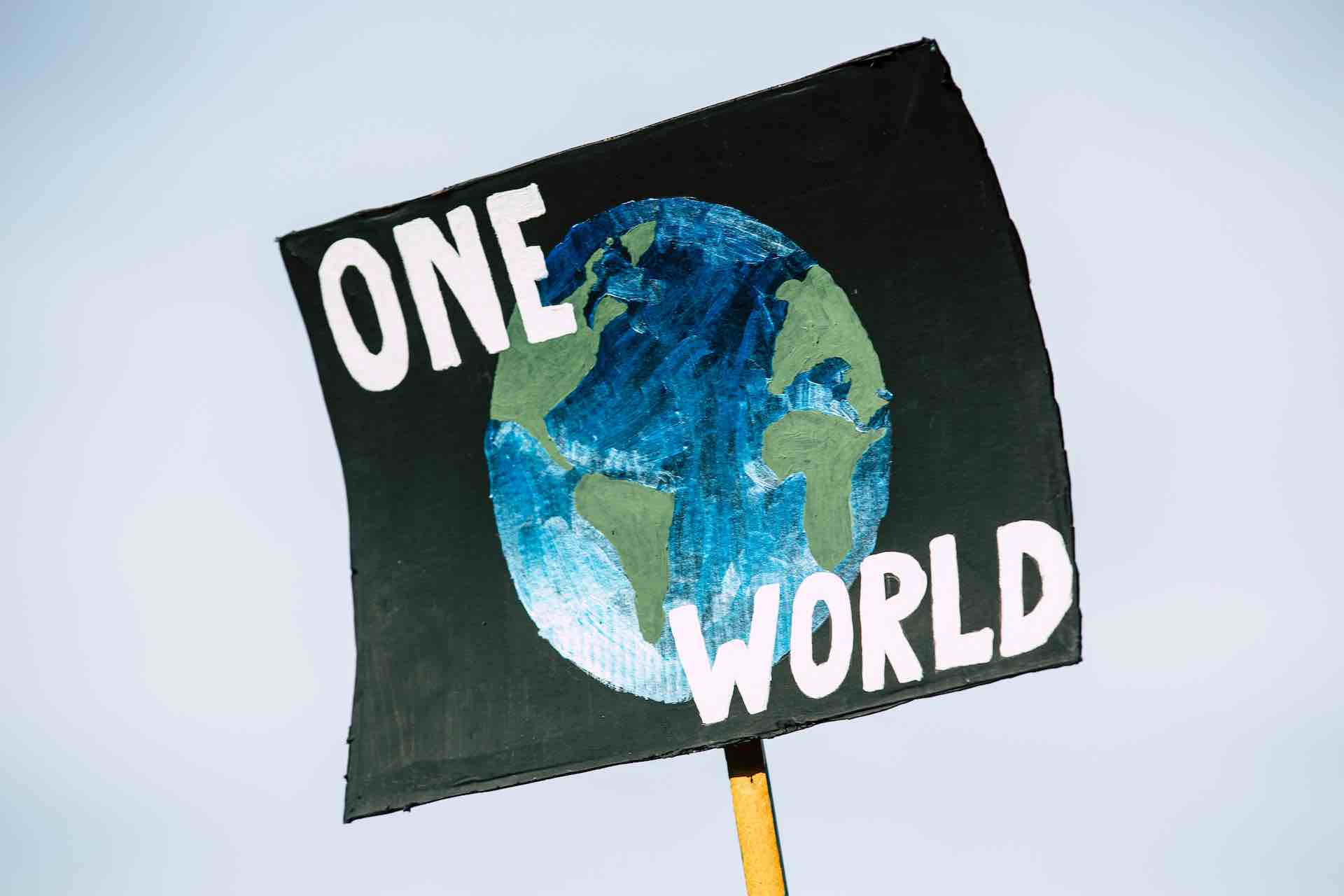 Dmonstrations-plakat med texten "One World"
